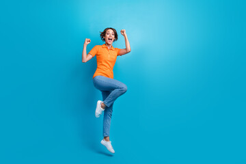 Fototapeta na wymiar Full size photo of gorgeous girl dressed stylish polo denim trousers flying hold arms behind head isolated on blue color background