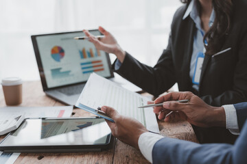 Business people meeting explaining the financial graph data and marketing plan. Group of Business people meeting and using graphs, charts, presented at company sales strategy marketing meeting.