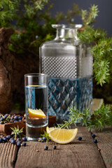 Gin with ingredients on an old wooden table.