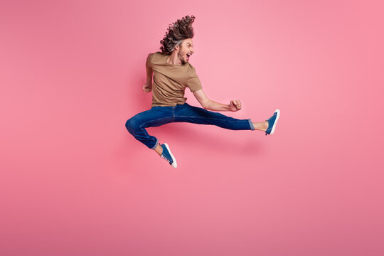 Full size photo of dangerous man with long hairstyle dressed beige t-shirt practicing martial arts isolated on pink color background - Powered by Adobe