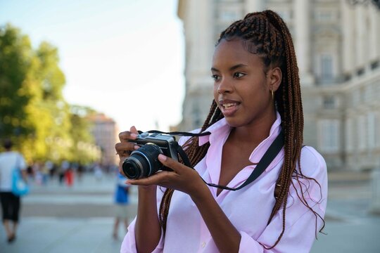 Cuban female tourist sightseeing with her camera in Madrid, Spain.