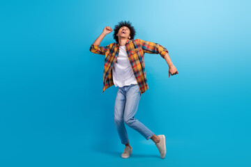 Full length photo of funky excited guy dressed checkered shirt dancing having fun empty space isolated blue color background