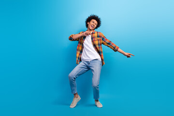 Full length photo of positive handsome guy dressed checkered shirt dancing having fun isolated blue color background