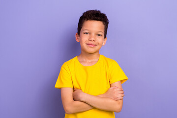 Photo of cheerful adorable boy wear yellow clothes standing with folded arms isolated on purple color background