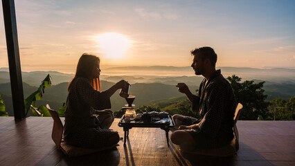Fototapeta na wymiar a couple on vacation in Thailand waking up with drip coffee in the morning during vacation, with a look at the mountains of Doi Chang Chiang Rai Thailand