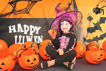 Pretty little girl dressing up as a witch in a Halloween setting - 661794492