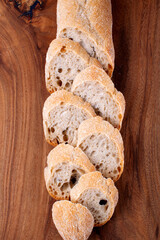 Baguette sliced on wooden board. Top view. Fresh homemade bread