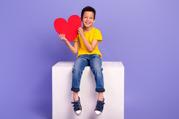 Full size photo of cute young schoolboy hold red big heart romantic dressed yellow clothes isolated on violet color background