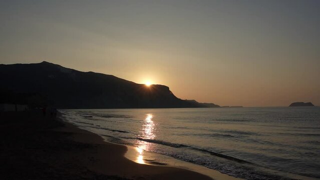 A video of the sun peaking over the mountain on Kalamaki Beach on the Island of Zante.