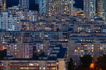 View of a residential district of the city at night. Glowing windows of multi-storey residential buildings
