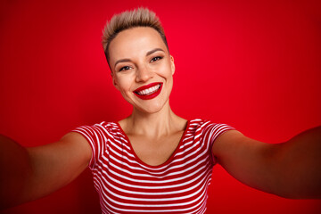 Photo of positive lovely girl wearing striped clothes blogging chatting followers isolated on red color background