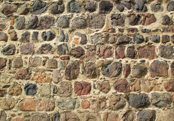 Textur einer Wand auf vielen Feldsteinen gemauert.