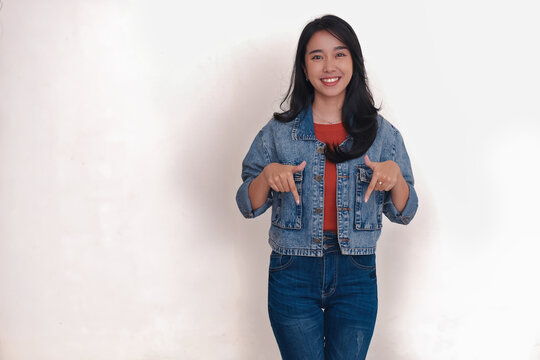 Happy facial expression of an Asian girl standing with both fingers pointing down