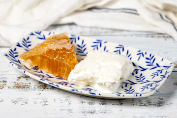 Honey and clotted cream on a plate. Honey and clotted cream for breakfast on wooden background. Close up