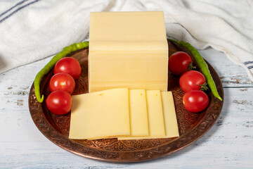 Fresh cheese or kashkaval in a copper plate. Fresh cheddar cheese on wooden background. local name...