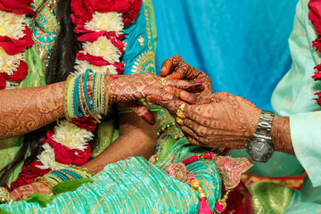 Obraz na płótnie Canvas Indian groom wearing ring in bridal hand 