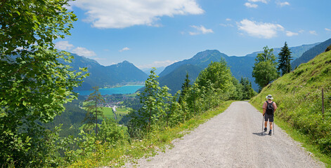 hiker at route to Feilkopf mountain, view to lake Achensee and tirolean alps - obrazy, fototapety, plakaty