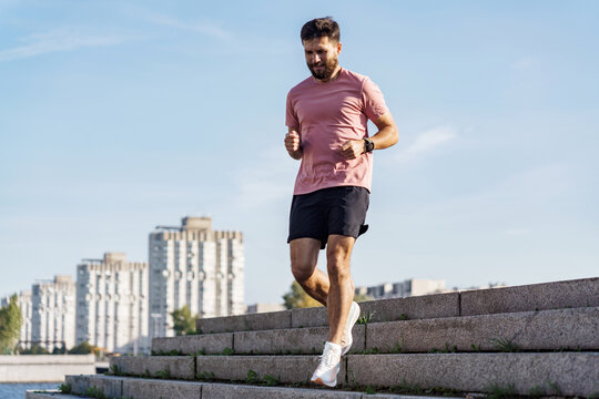 The man is a professional running instructor. Fitness training in sportswear T-shirt and shorts.  Motivating photo for an active and healthy lifestyle.