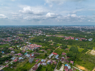 Aerial View of Pekanbaru city skyline with many trees in Indonesia. The capital city of Riau province with many residential buildings.