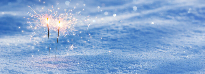 two burning sparklers in snow, party together concept banner background with copy space for happy new year or merry christmas or other festive holiday events - obrazy, fototapety, plakaty