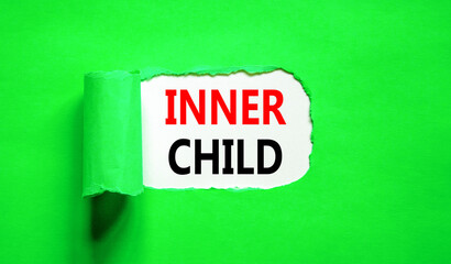 Inner child symbol. Concept words Inner child on beautiful white paper. Beautiful green table green background. Psychological, motivational inner child concept. Copy space.