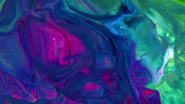 This stock video features an extreme close-up shot of a thick mixture of colored liquid paints spreading on the surface in slow motion. 