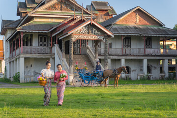 Beautiful Asian women dressed in Thai traditional dress clothing and horse-drawn carriage at Wat Chaimongkol (Jong Kaha) ancient Burmese Temple old historical evidence Burmese in Lampang, Thailand.
