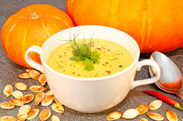 Pumpkin hot puree soup on a wooden table