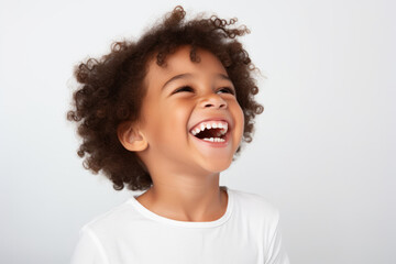 Portrait of a cute happy smiling mixed race boy child model with perfect clean face and curly hair isolated on white background