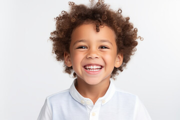 Portrait of a cute happy smiling mixed race boy child model with perfect clean face and curly hair isolated on white background