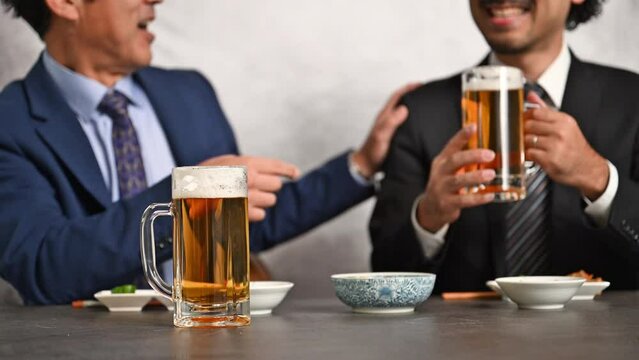 居酒屋で上司とビール飲むビジネスマン　パワハラ気味の上司をかわすのがうまい部下のノミニケーション動画 顔がぼけて使いやすい(顔無し)