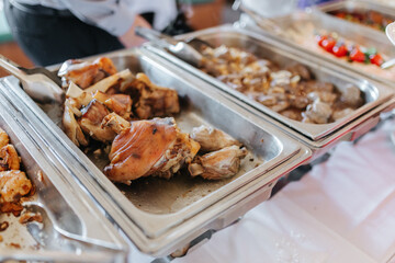 Cooked pork in a silver tray as part of a wedding buffet