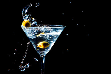 Olive splashing into a martini glass
 - obrazy, fototapety, plakaty