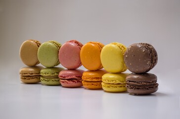 French macarons or Assorted colorful macaroons, side view. Colorful holiday treats, almond cookies. Sweet meringue-based confection made with egg white, icing sugar, granulated sugar, almond