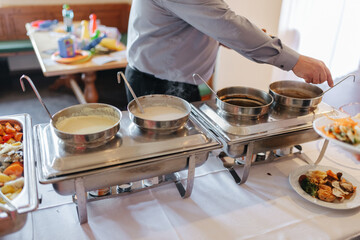 Different sauces in silver pots at a wedding buffet 