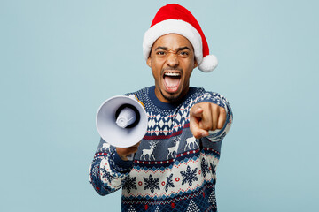Young man in sweater Santa hat posing scream in megaphone announces discounts sale Hurry up point...