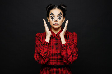 Young astonished woman with Halloween makeup face art mask wear clown costume red dress spread...