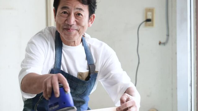 サンダーをかける男性 お家でDIY 趣味の時間の動画
