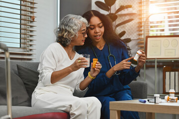 An African-Asian nurse or caregiver woman advice the daily medicine to the old woman