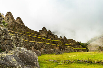 Fototapeta na wymiar machu picchu panorama with the mountains behind. This is other view of the ruins of Machu Picchu between the clouds in a cloudy day. Archeological site between the mountains
