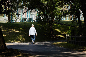 Obraz premium 秋の公園で散歩しているシニア男性の姿