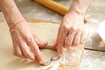 Young man kneading dough on wooden table. Males hands making bread on the kitchen. Baking concept.