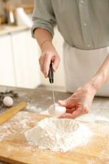 Young man kneading dough on wooden table. Males hands making bread on the kitchen. Baking concept.