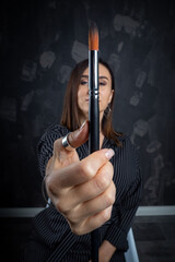 Portrait of a female artist, with brushes in her hands..