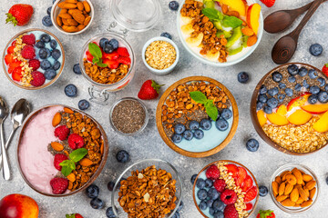 Bowl of granola with yogurt and fresh berries on a texture table. Yogurt berries, acai bowl, spirulina bowl. Healthy food, balanced breakfast. Strawberries, blueberries, kiwi, peach, almonds and chia.
