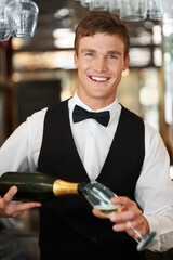 Man, bartender and waiter with champagne at restaurant for happy hour, hospitality industry or customer service. Portrait of barman, server or catering employee smile, wine glass and alcohol bottle