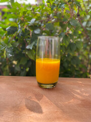 Orange juice in a glass at wooden table.