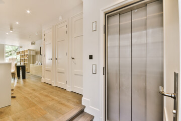 a kitchen and living room in a house with white walls, hardwood flooring and stainless steel door handles on the doors