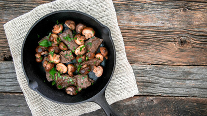 Bottom beef sirloin steak tips and baby bella mushrooms from above with copy space - obrazy, fototapety, plakaty