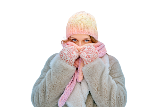 A smiling woman wraps herself in clothes warming up in a winter forest with trees in the snow, isolated on a white background